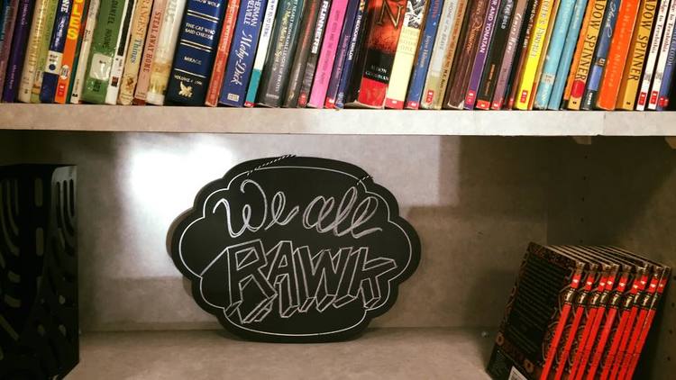 WE ALL RAWK Sign on Bookshelf - Read and Write Kalamazoo